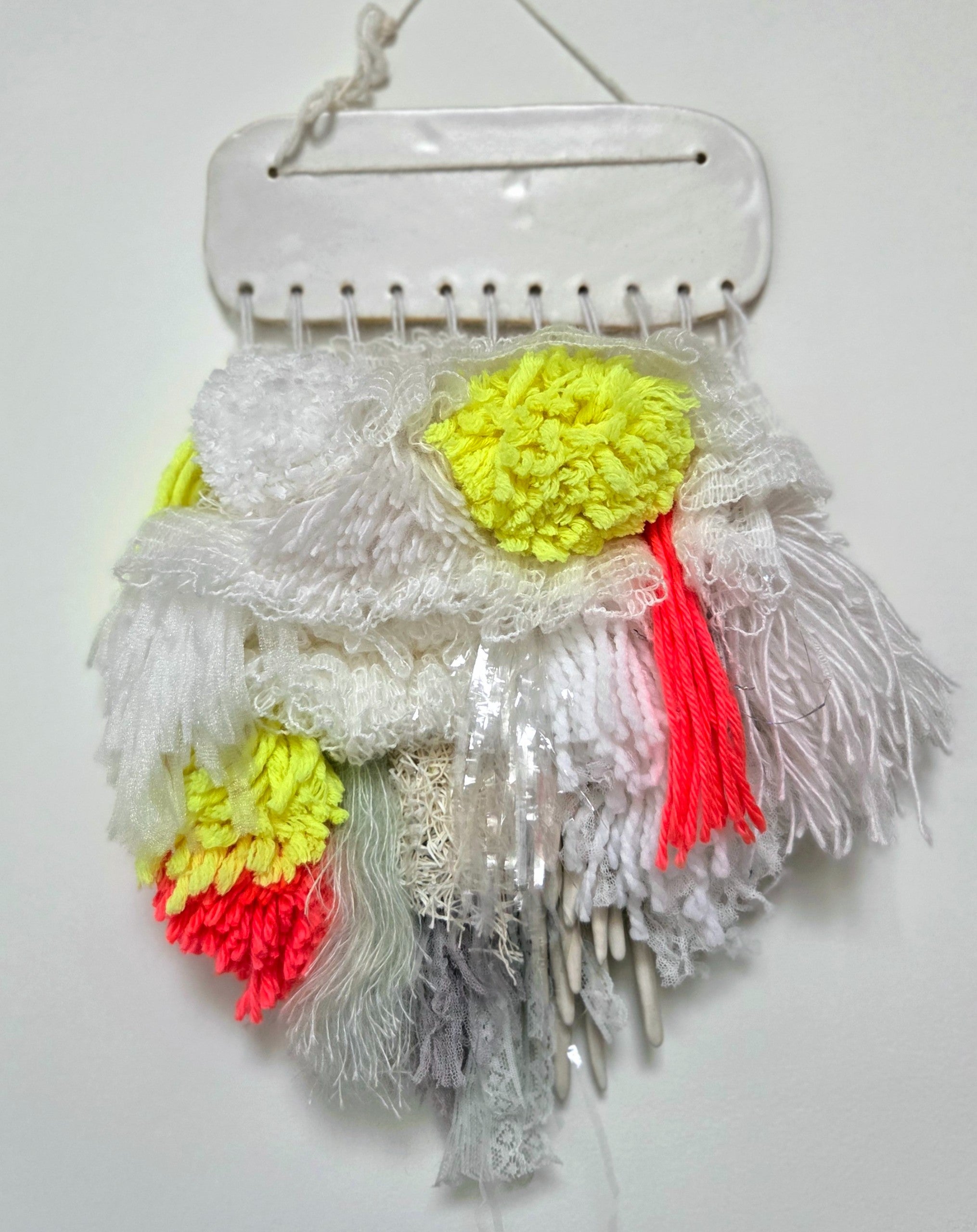 Silence in Between — an embroidered textile in the style of Finnish Ryijy weaving, moving from soft whites to neon red and yellow, with lace, plastic and ceramic yarns