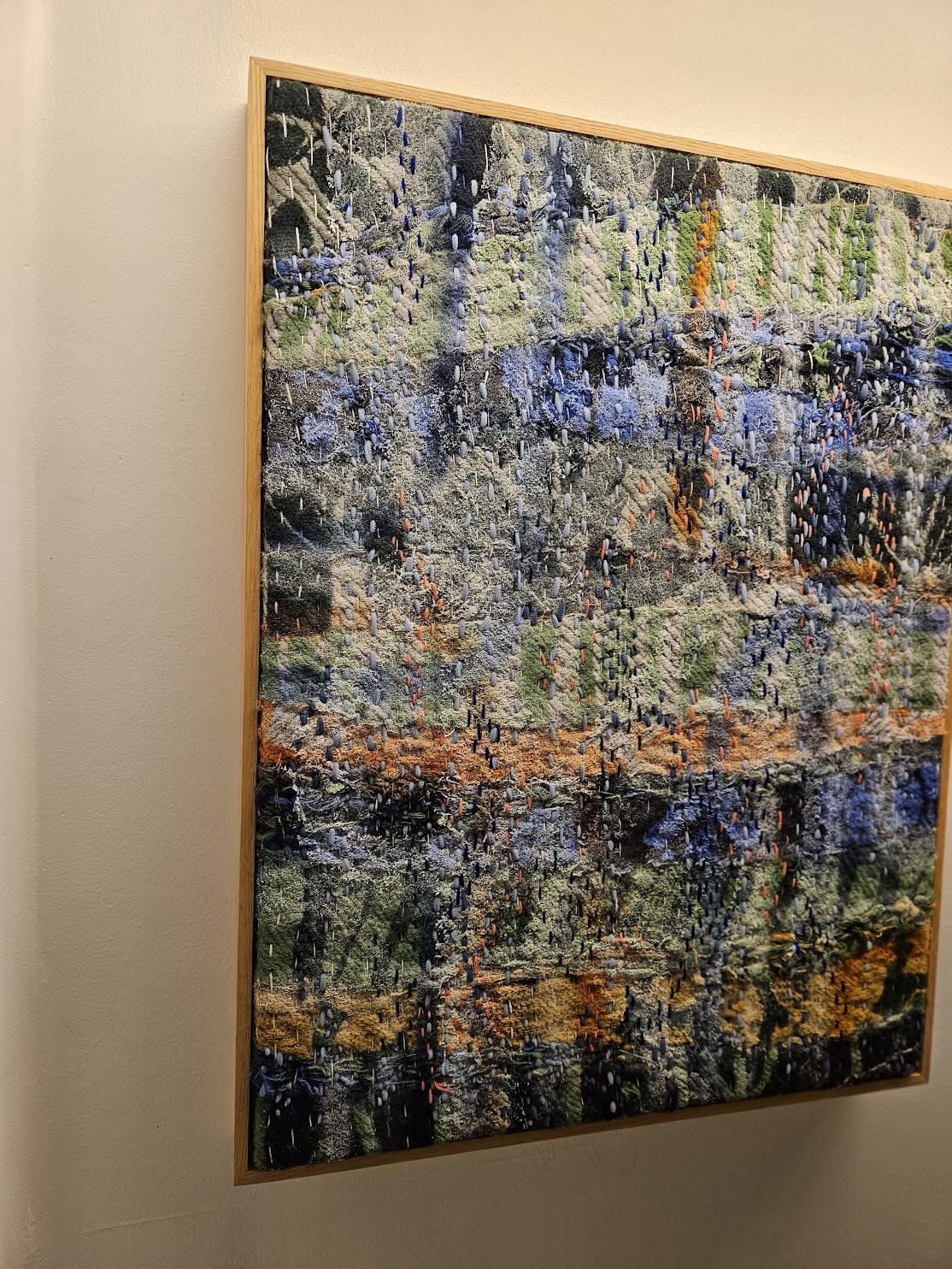 Close-up of dense sashiko hand-stitching over layered jacquard, vintage yarns and pale knitted fibers